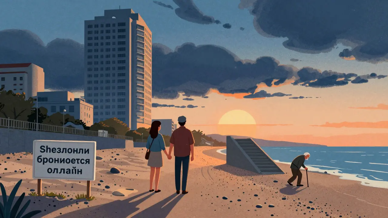 Пара на каменистом пляже при закате, за ними высокий отель с тенью и лестницей к морю.